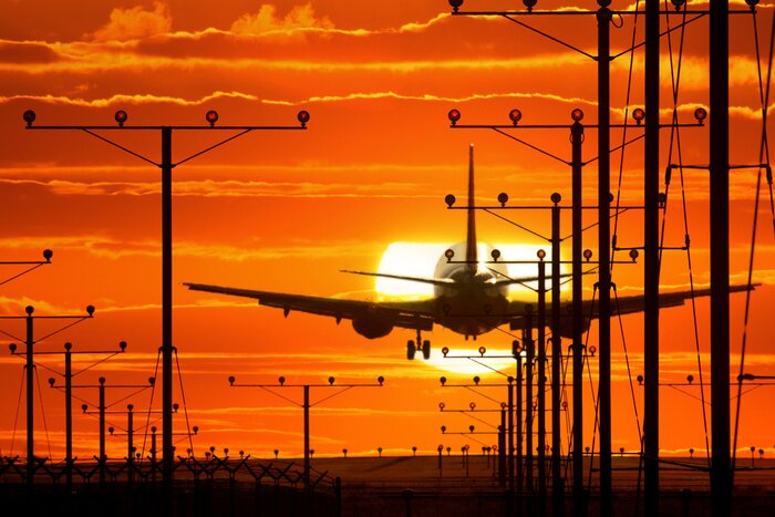 Bild Flugzeug landet bei Sonnenuntergang