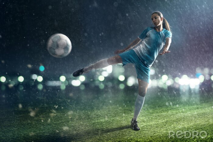 Bild Fußballspielerin im Regen mit Fußball