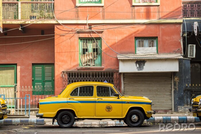 Bild Gelbes Taxi vor dem Hintergrund des roten Hauses