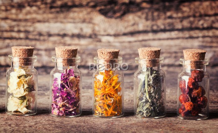 Bild Gläser mit getrockneten Kräutern und Blumen auf Holz