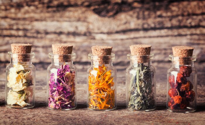 Bild Gläser mit getrockneten Kräutern und Blumen auf Holz