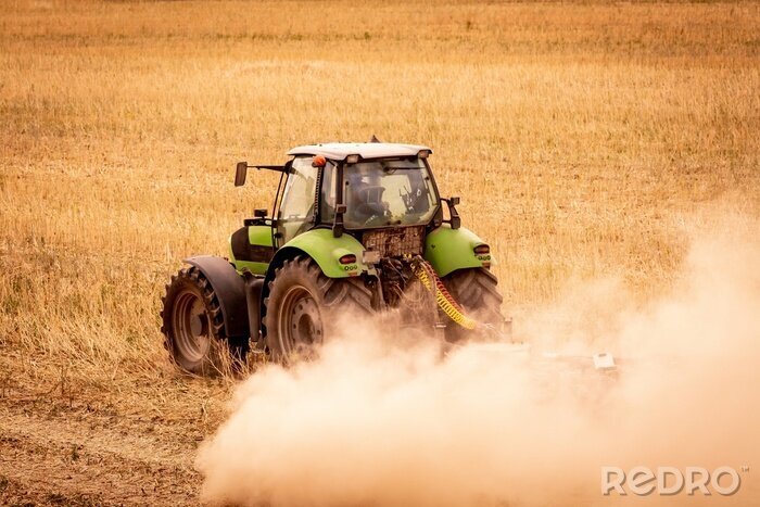 Bild Grüner Traktor und Staubwolke