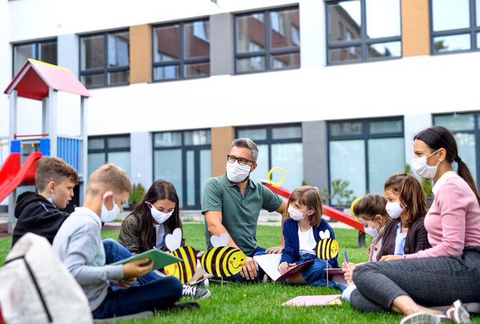 Bild Kinder mit Masken vor der Schule