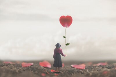 Bild lonely romantic woman holds a giant petal made to heart