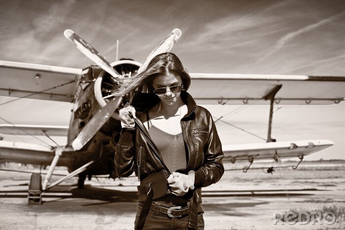 Bild Mädchen in schwarzer Jacke und Flugzeug
