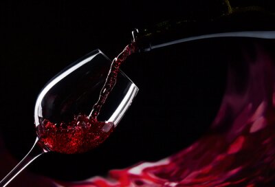 Rotwein in ein Glas eingießen