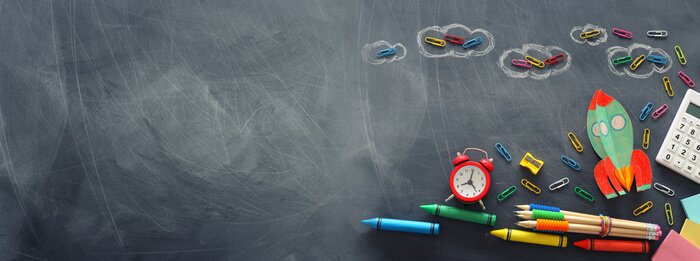 Bild Schulzubehör mit der Tafel im Hintergrund