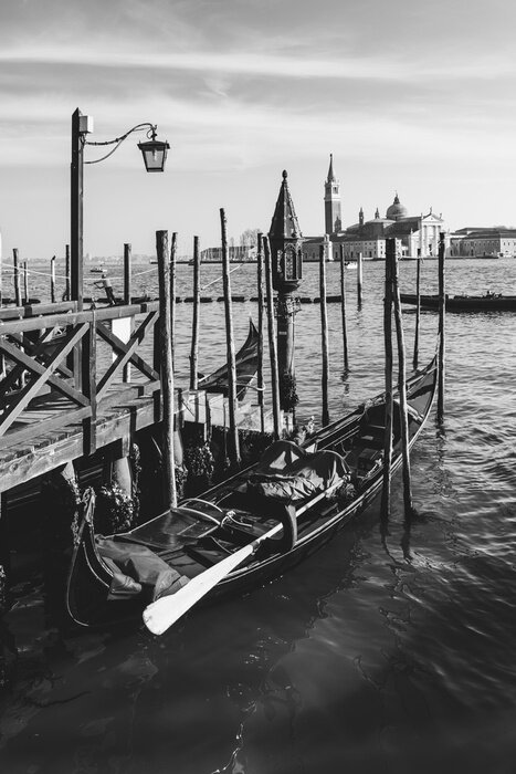 Bild Schwarz-weißes Holzboot beim Steg