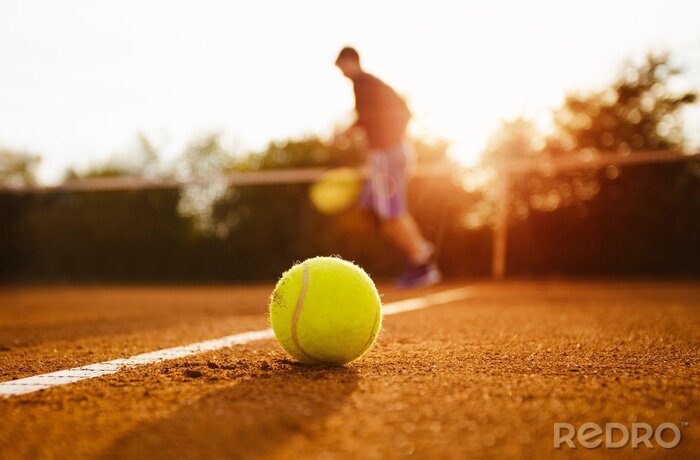 Bild Tennisball auf sonnigem Tennisplatz