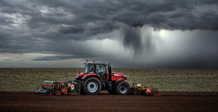 Bild Traktor auf dem Feld während des Sturms