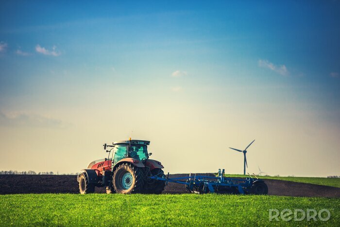 Bild Traktor mit einer Windmühle im Hintergrund