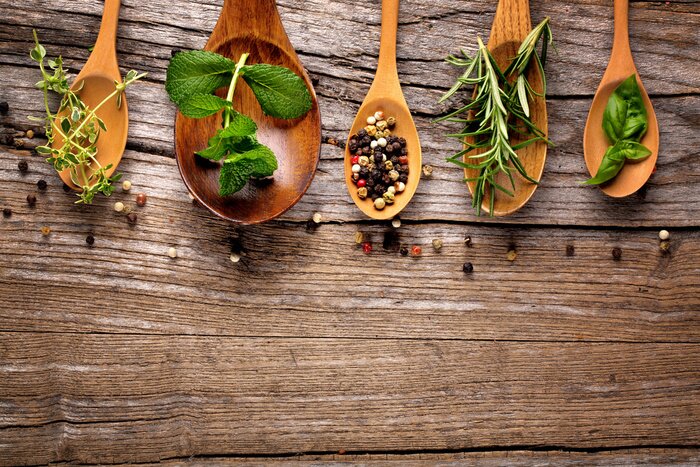 Bild Verschiedene Gewürze und Kräuter auf Holzlöffeln angerichtet