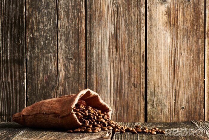 Bild Verschüttete Kaffeebohnen auf Holz