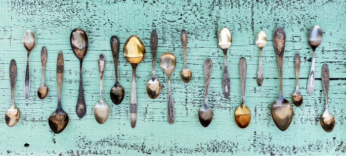 Fototapete Alte Löffel in einer Reihe auf türkisfarbenen Brettern