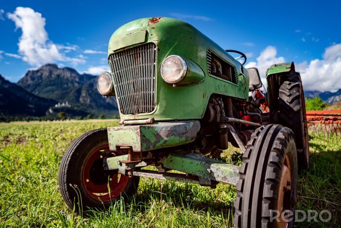 Fototapete Alter Traktor im Hintergrund der Alpen