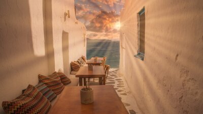 Fototapete Benches with pillows in a typical Greek bar in Mykonos town with sea view, Cyclades islands, Greece. Travel concept.