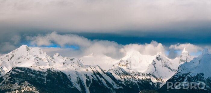 Fototapete Berge im Schnee und dunkle Wolken
