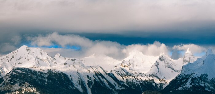 Fototapete Berge im Schnee und dunkle Wolken