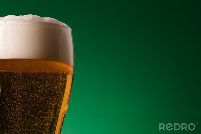 Fototapete Bier mit Schaum auf grünem Hintergrund