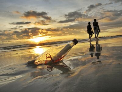 Brief in einer Flasche am Strand vergraben