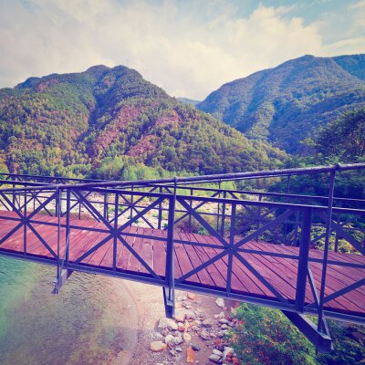Fototapete Brücke über felsigem Fluss