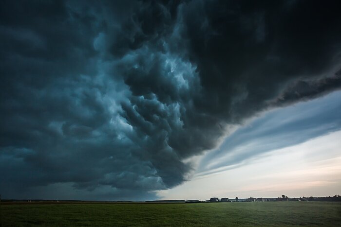 Fototapete Dunkle Wolken über einem Feld