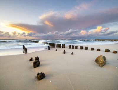 Fototapete Dynamische Landschaft des Meeres, die Wellen brechen auf dem Wellenbrecher, Sonnenuntergang am Meer Strand