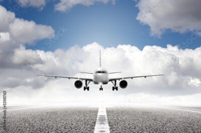 Fototapete Ein Flugzeug hebt vor einem Wolkenhintergrund von der Landebahn ab