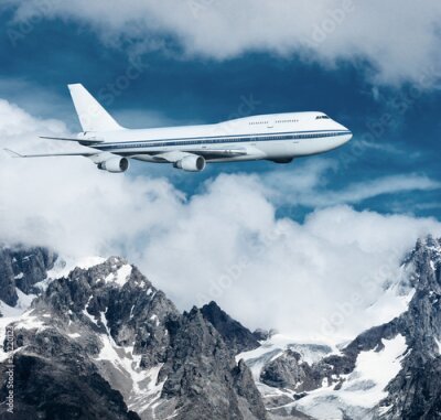 Fototapete Ein Passagierflugzeug über schneebedeckten Bergen