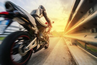 Fototapete Ein schneller Motorradfahrer auf der Straße