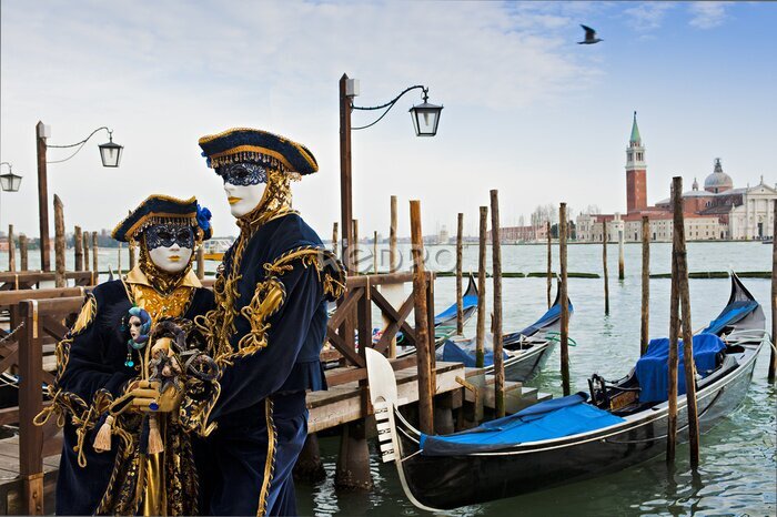 Fototapete Eine Frau und ein Mann mit Karnevalsmasken vor der Kulisse von Venedig