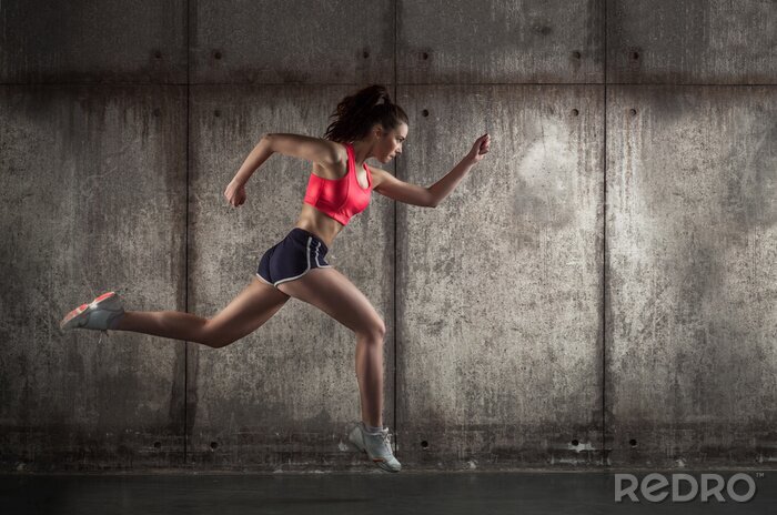 Fototapete Eine laufende Frau in Sportkleidung im Profil