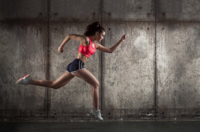 Fototapete Eine laufende Frau in Sportkleidung im Profil