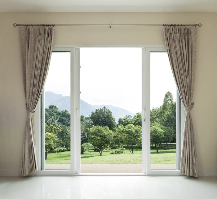 Fototapete Eine offene Tür mit Blick auf einen grünen Garten