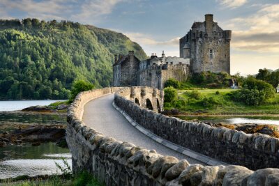 Fototapete Evening light on restored Eilean Donan Castle on Island at three lochs with added stone arch footbridge Scottish Highlands Scotland UK