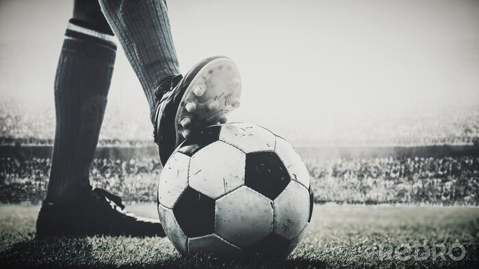 Fototapete feet of soccer player tread on soccer ball for kick-off in the stadium black and white