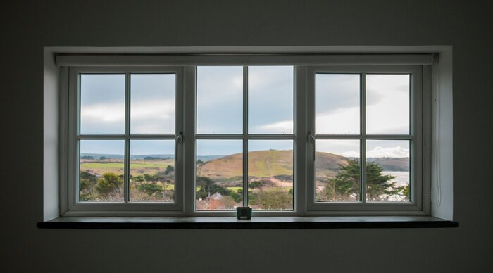 Fototapete Fenster mit Blick auf einen Hügel