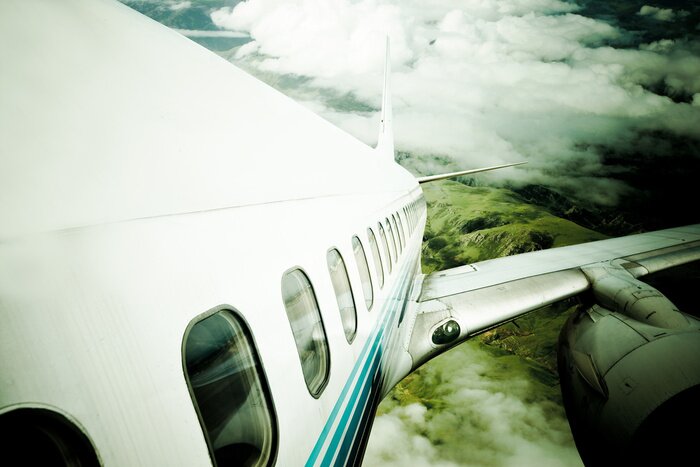 Fototapete Flugzeug in dunklen Wolken