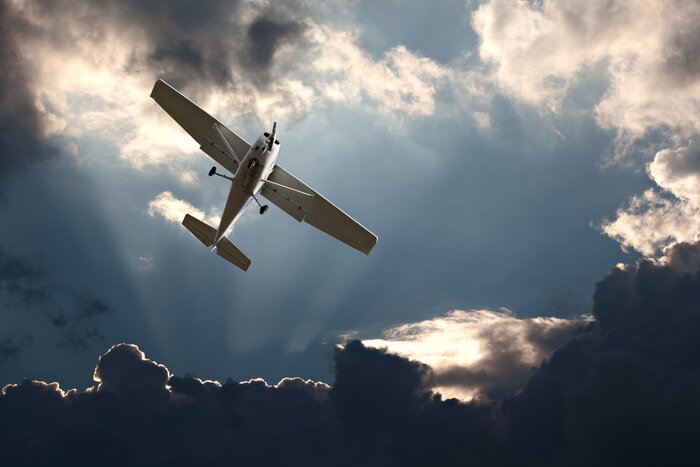 Fototapete Flugzeug mit stürmischem Himmel im Hintergrund