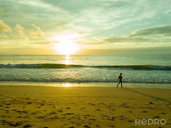 Fototapete Frau am Strand bei Sonnenuntergang