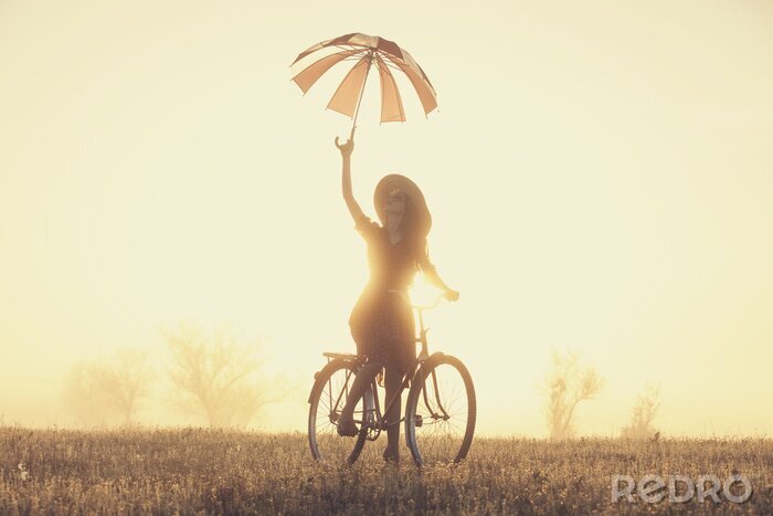 Fototapete Frau auf dem Fahrrad mit Regenschirm