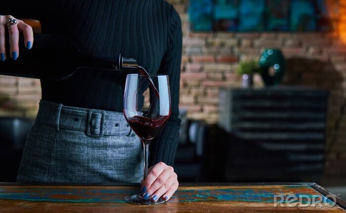 Fototapete Frau gießt Wein in ein Glas