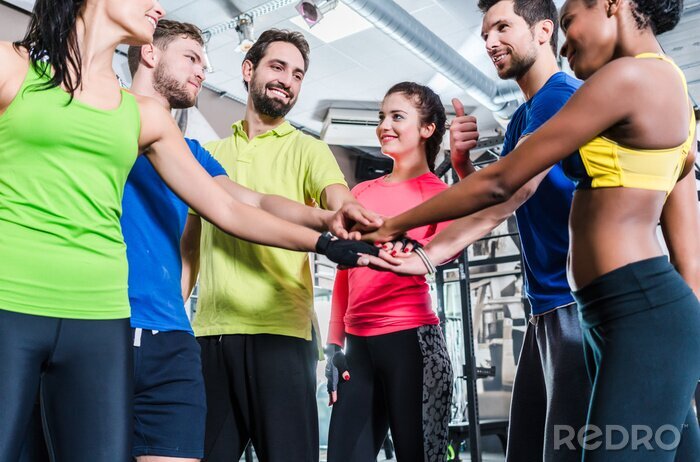 Fototapete Frauen und Männer sind motiviert für Sport und Eignung und stapeln die Hände