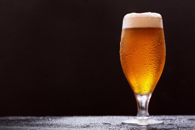 Gekühltes Glas Bier auf dunklem Hintergrund