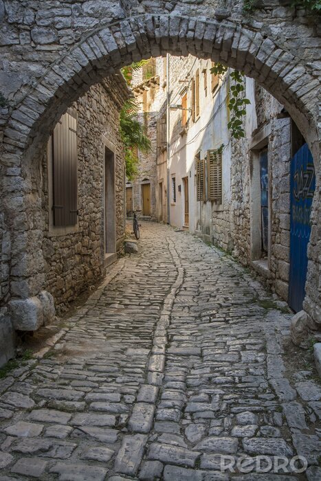 Fototapete Gepflasterte Gasse mit Säulen