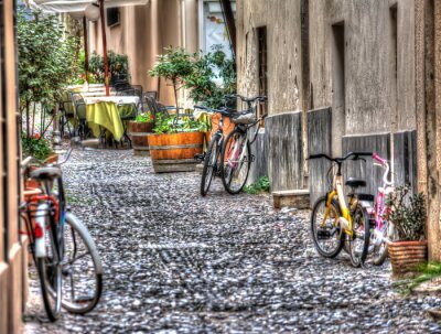 Fototapete Gepflasterte Straße mit bunten Fahrrädern