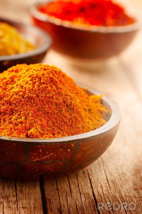 Fototapete Gewürze in Schalen auf Holztischplatte