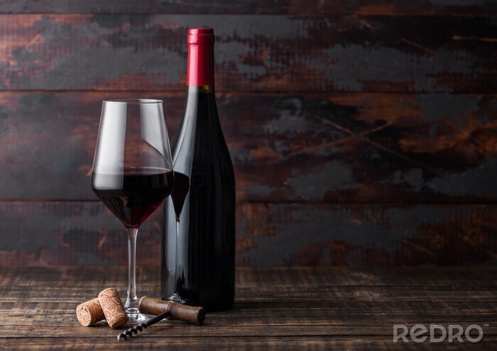 Fototapete Glas Wein und Flasche vor dem Hintergrund des Holzes