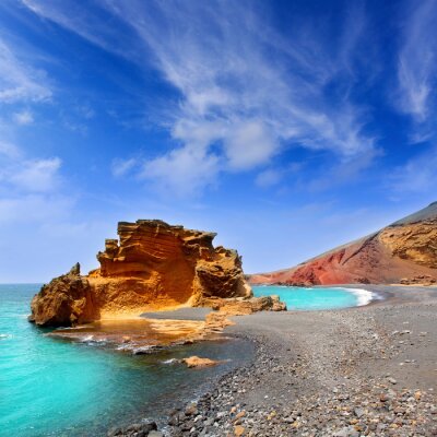 Grauer Strand und türkisfarbenes Meer