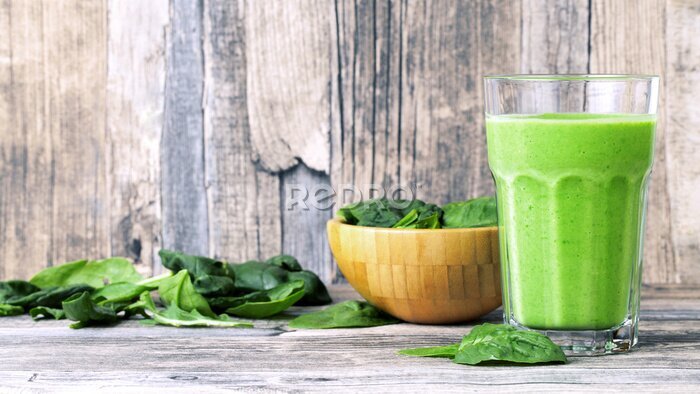 Fototapete green smoothie juice on wooden table with spinach